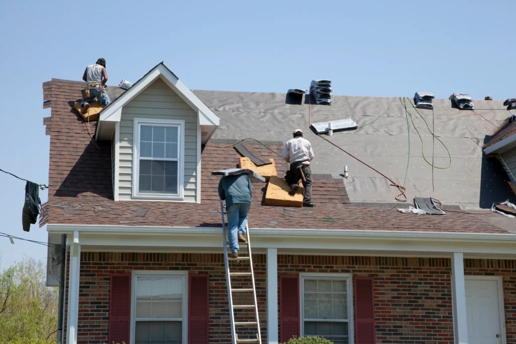 contractors on roof using tools to make replacement