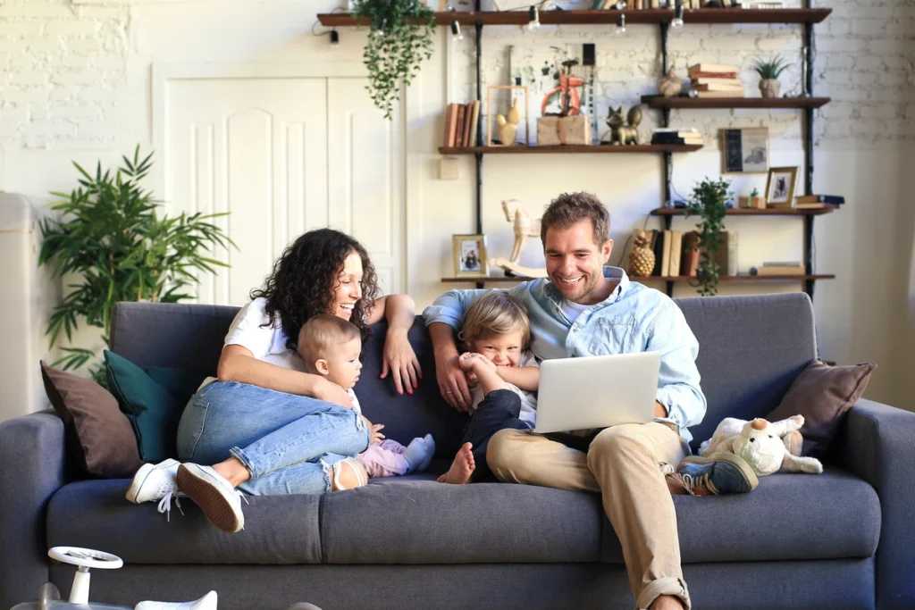 young family on couch researching roof replacement on computer