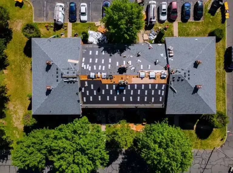 large crew replacing the apartment building roof
