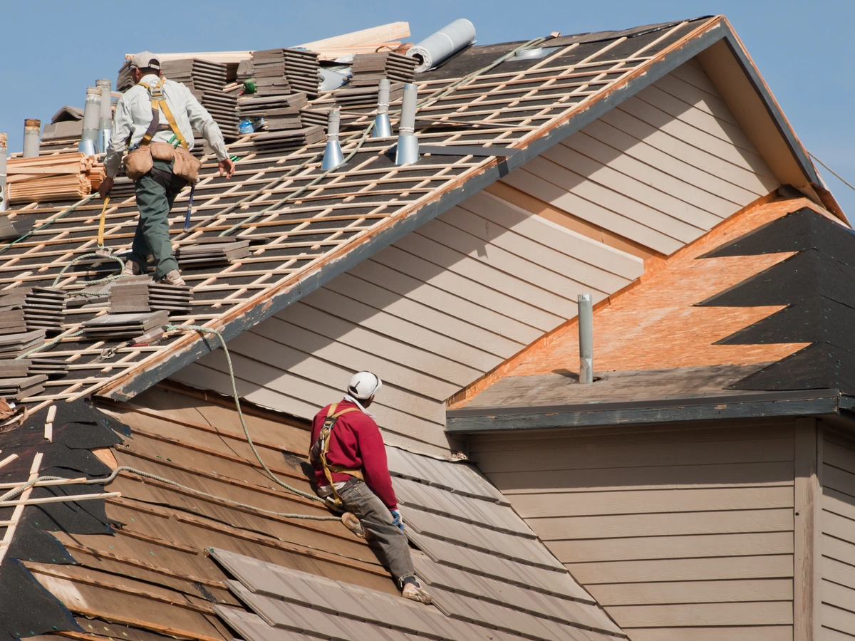 house roof being repaired by workers