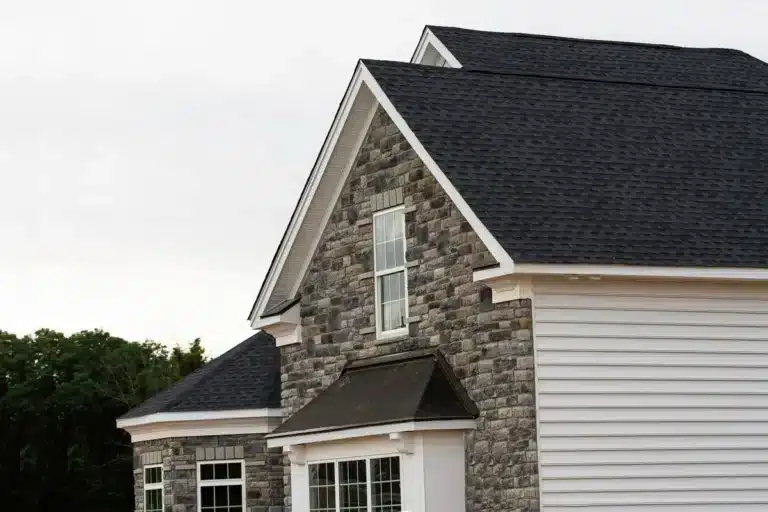 Dark shingle roof on brick and white siding house